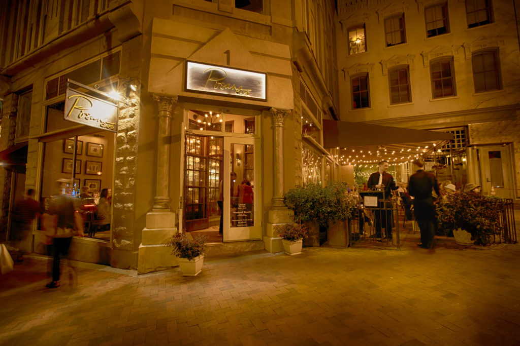 Night time photo of a restaurants on a cobble street in Asheville